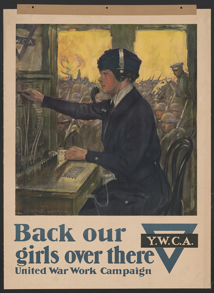 Woman working on a broadcasting machine with soldiers lined up in the background. Caption: "Back our girls over there - United War Work Campaign, Y.W.C.A."